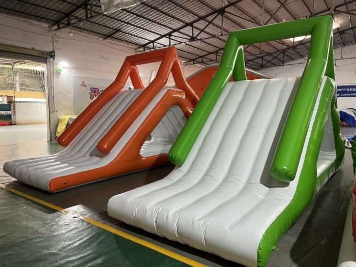 Orange and green multi-lane inflatable floating slides for water park entertainment
