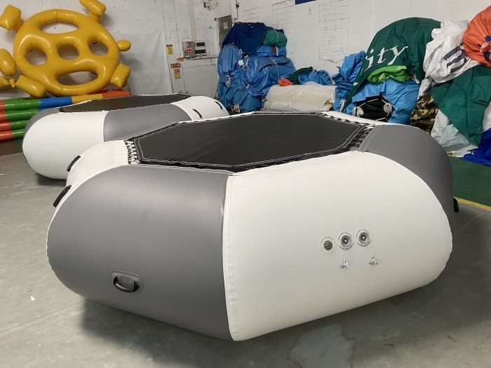 Gray and white inflatable water trampolines with visible air valves and carry handle