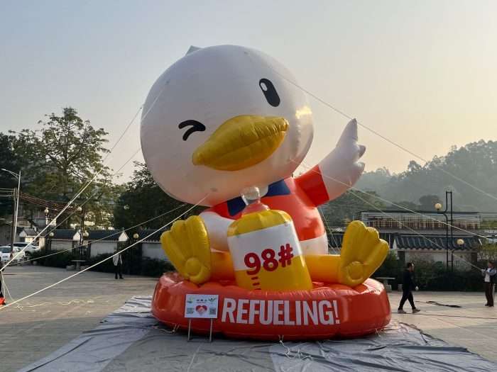 Front view of giant inflatable refueling duck mascot holding 98 fuel bottle, 8m