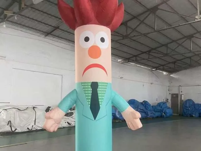 Front view of a red-haired inflatable air dancer character with wide eyes, orange nose, and teal business suit
